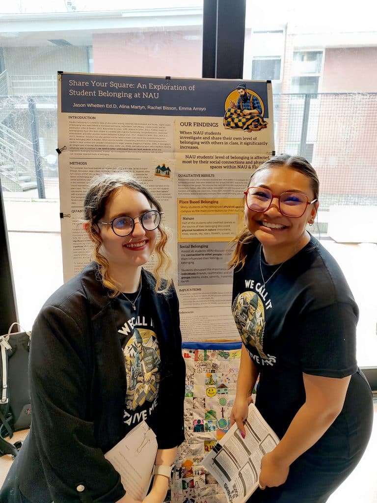Two students posing in front of a research poster