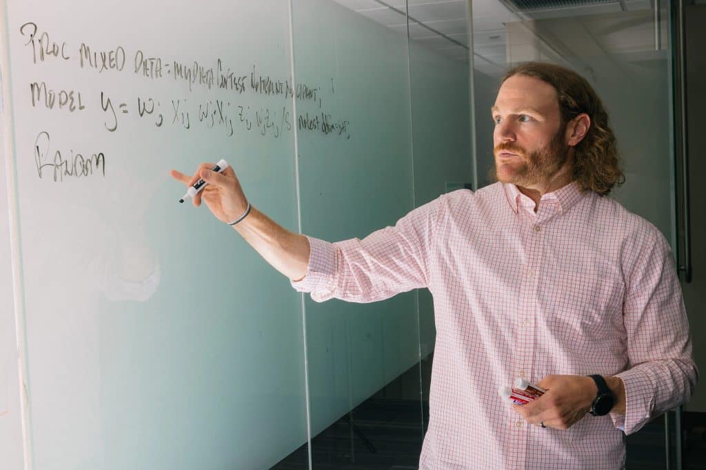 Robert Wickham doing mathematical calculations on a whiteboard