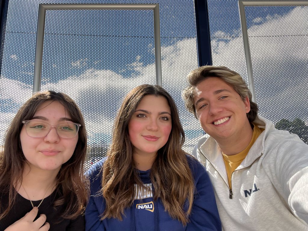 Henry Petterson posing in a selfie with two friends wearing NAU gear