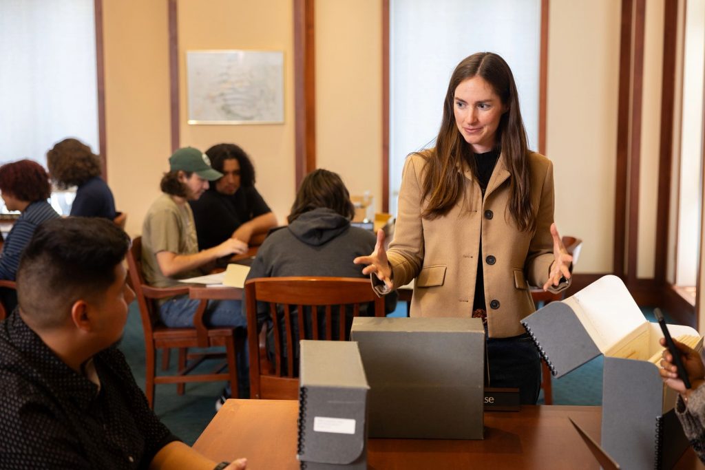 Lauren Lefty speaking to a seated student inside the Cline Library