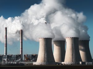 Smokestacks from a power plant spew steam into the sky.