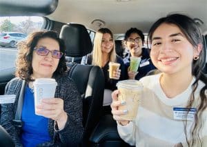 Members of the Multilingual Evaluation Team in the van with drinks as they leave for an appointment.