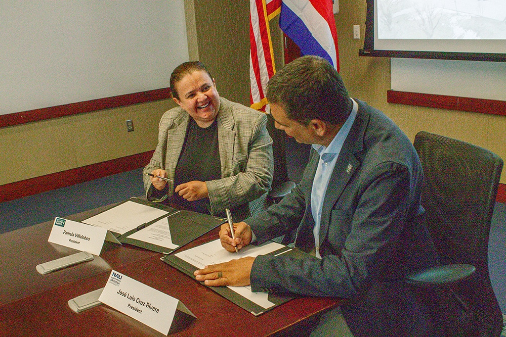 President Cruz Rivera and Pamela Villalobos, president and CEO of Castro Carazo University, sign an MOU.