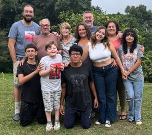 Marco Geserick posing with other generations of his family in front of shrubbery