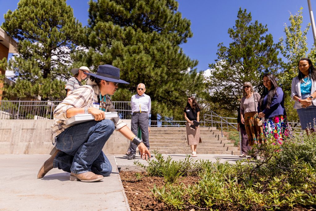 Sahale James pointing at a plant in Nakai Plaza