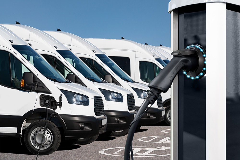 A fleet of electric vans at a charging station.