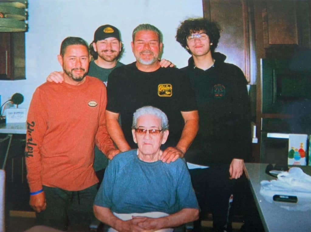 Nick Avelar, left, posing with his family