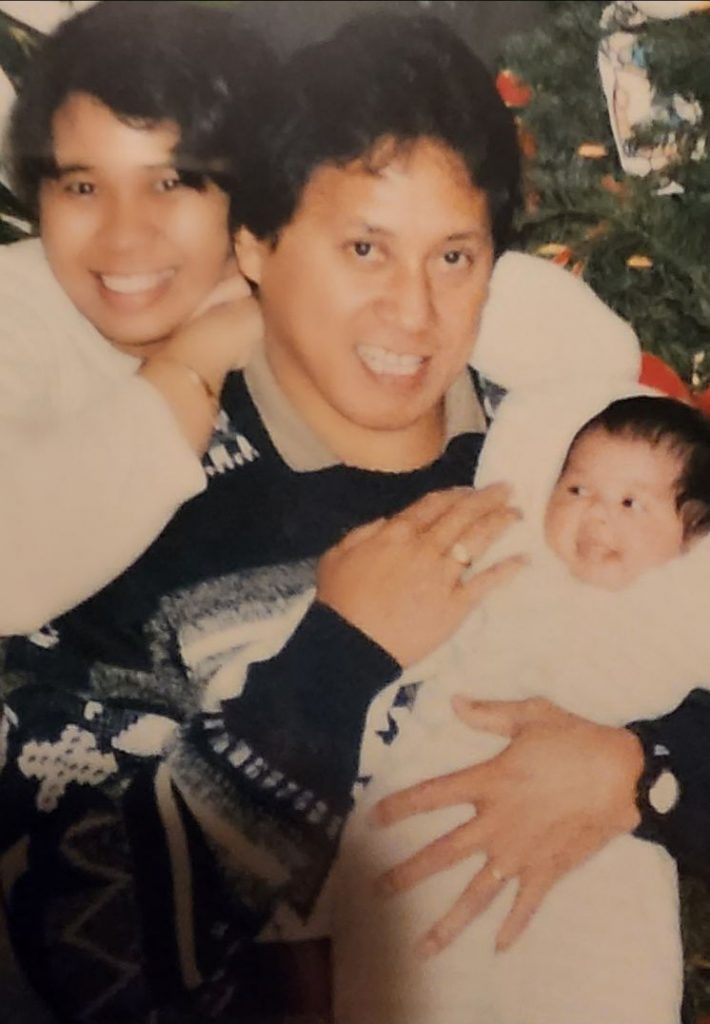 old family photo of two parents and their baby wearing winter clothes