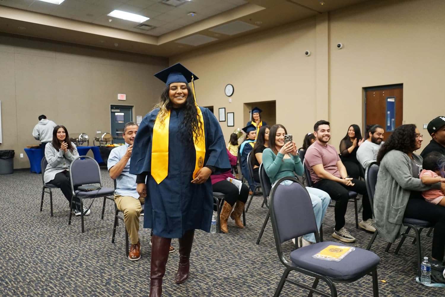 graduate in NAU regalia walking toward a stage