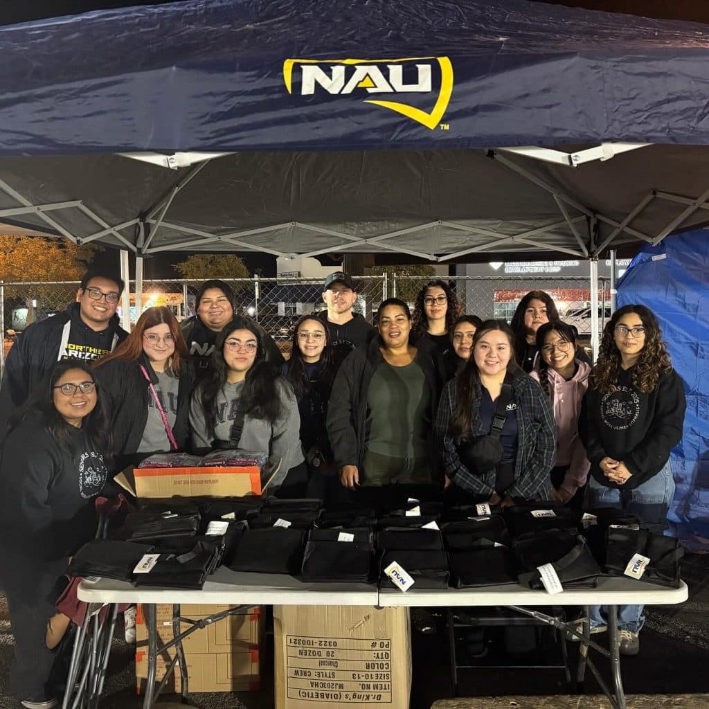 NAU-Yuma social work students pose behind the NAU booth at the 30th Dia del Campesino fair.