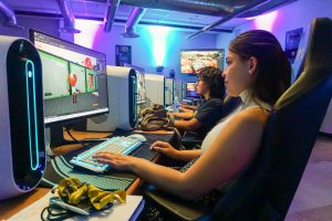 Students sitting in front of a computer designing a video game