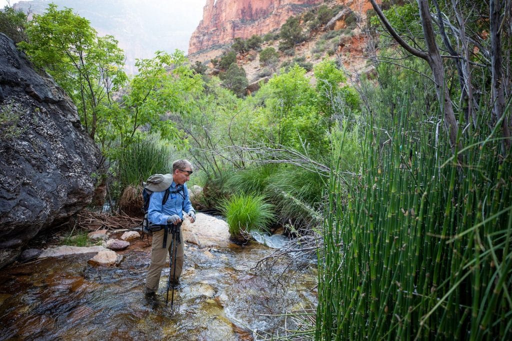 Abe Springer wading in water at the bottom of the Grand Canyon