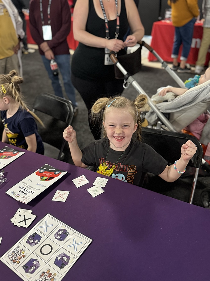 A young girl cheers while playing quantum tic-tac-toe.