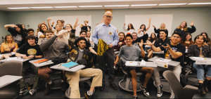 Alex Alvarez poses with his violent crime students in the back of his classroom.