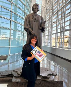 Olga Thomas at her naturalization ceremony with an American flag