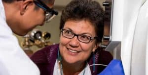 Jani Ingram looking up at a student dressed in a white lab coat