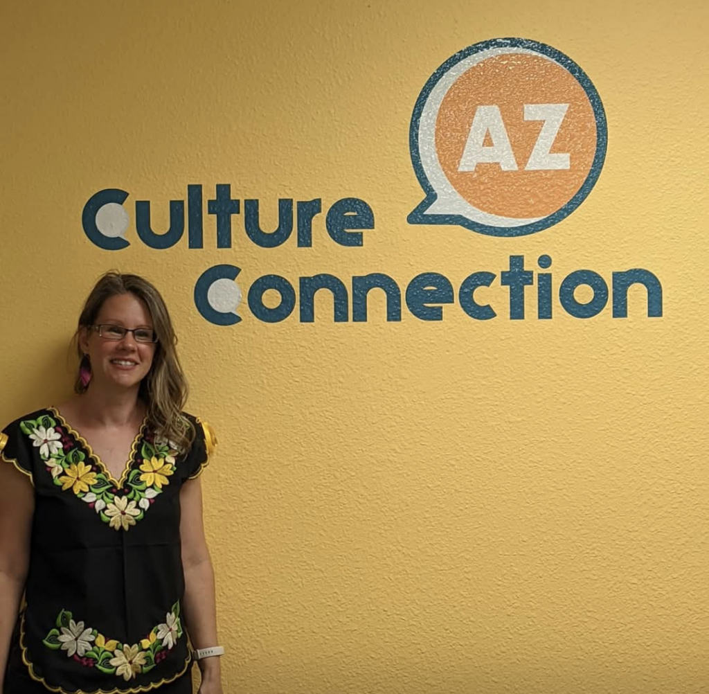 Audra Travelbee standing in front of a Culture Connection AZ sign