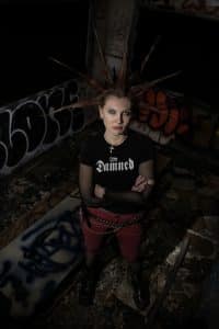 Portrait of a woman with spikey hair surrounded by graffiti