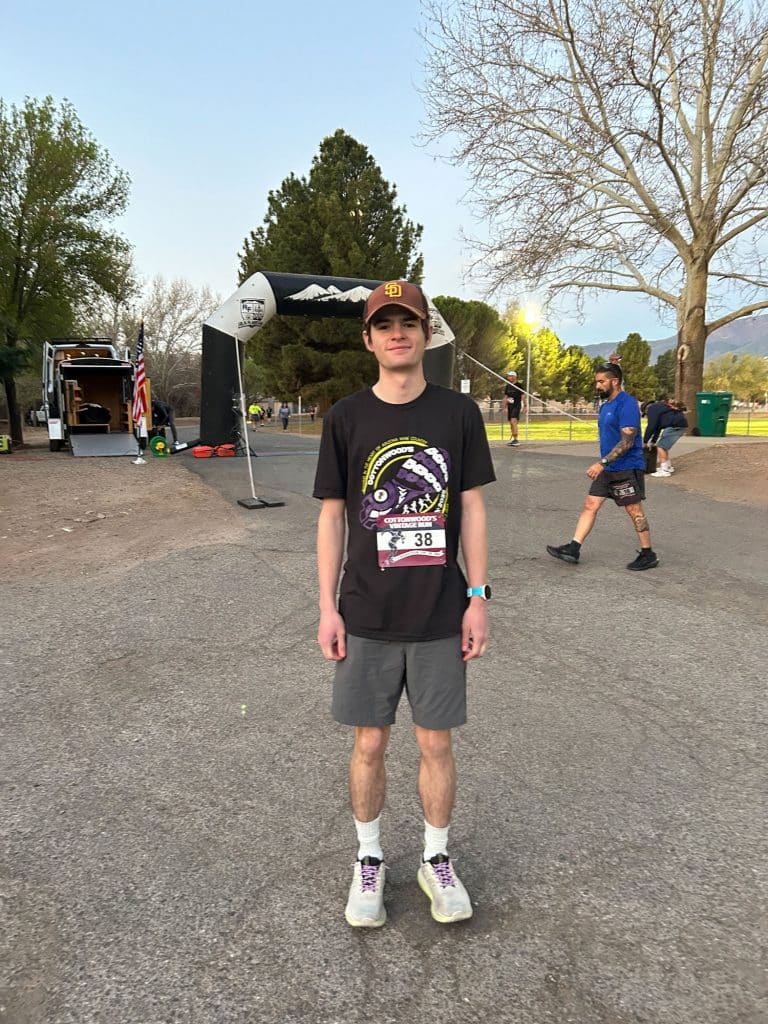 Henry Garland at the finish line of a half marathon race with a numbered bib