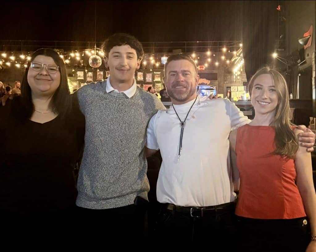 Three students with author they worked with during a marketing class