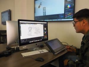 Student sitting in front of a computer working of animation