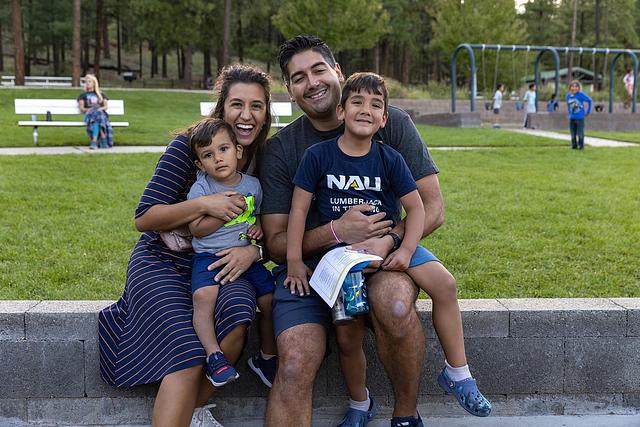 Two parents posing with their kids in a park
