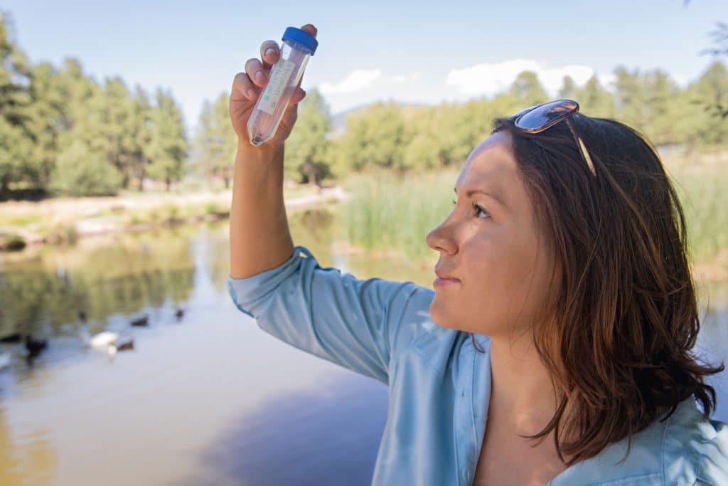 Crystal Hepp looking at a test tube at Frances Short Pond in Flagstaff