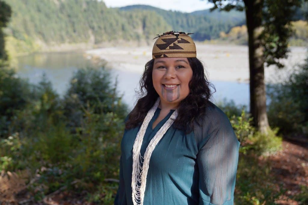 headshot of Seafha Ramos in front of a river meandering through an evergreen forest