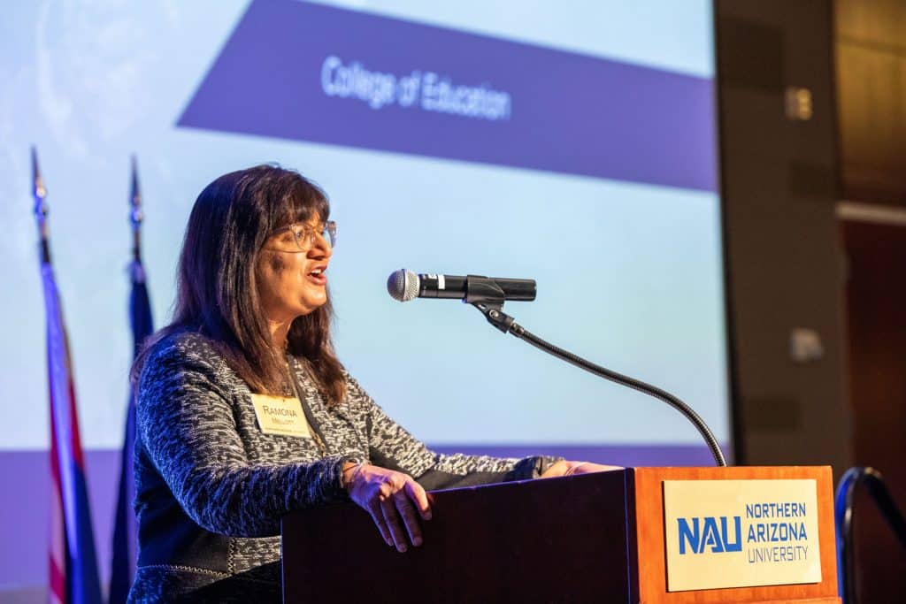 Ramona Mellott speaking at a podium with NAU branding