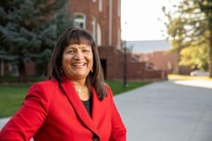 Headshot of Ramona Mellott in a red blazer outside on the NAU campus