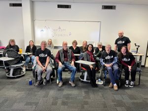 Students and seniors sitting at desks in a classroom in front of a whiteboard that says Mountain Tremors