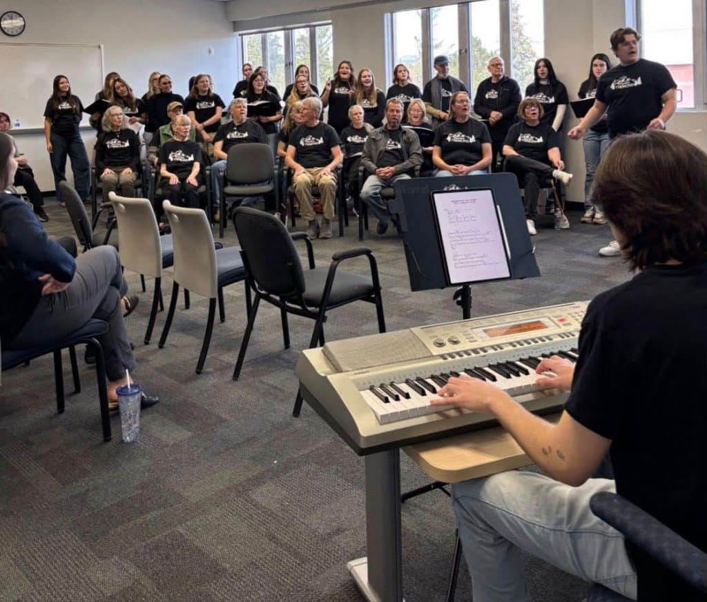 Keyboardist playing with music on an iPad with a choir in the background